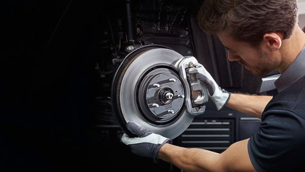 Ein Mechaniker erneuert die Bremsbeläge an einem Lexus