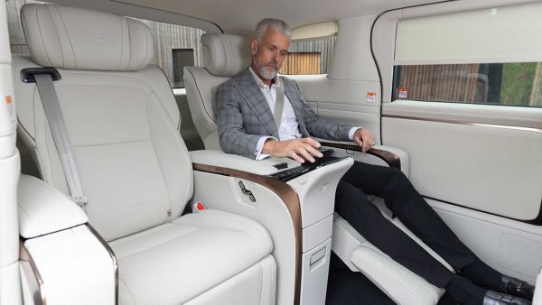 A rear passenger interacting with a Lexus LM's controls