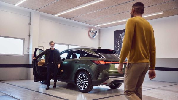 A driver exiting a parked Lexus whilst another person approaches
