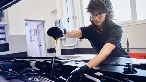 A Lexus mechanic mechanic checking a vehicles oil