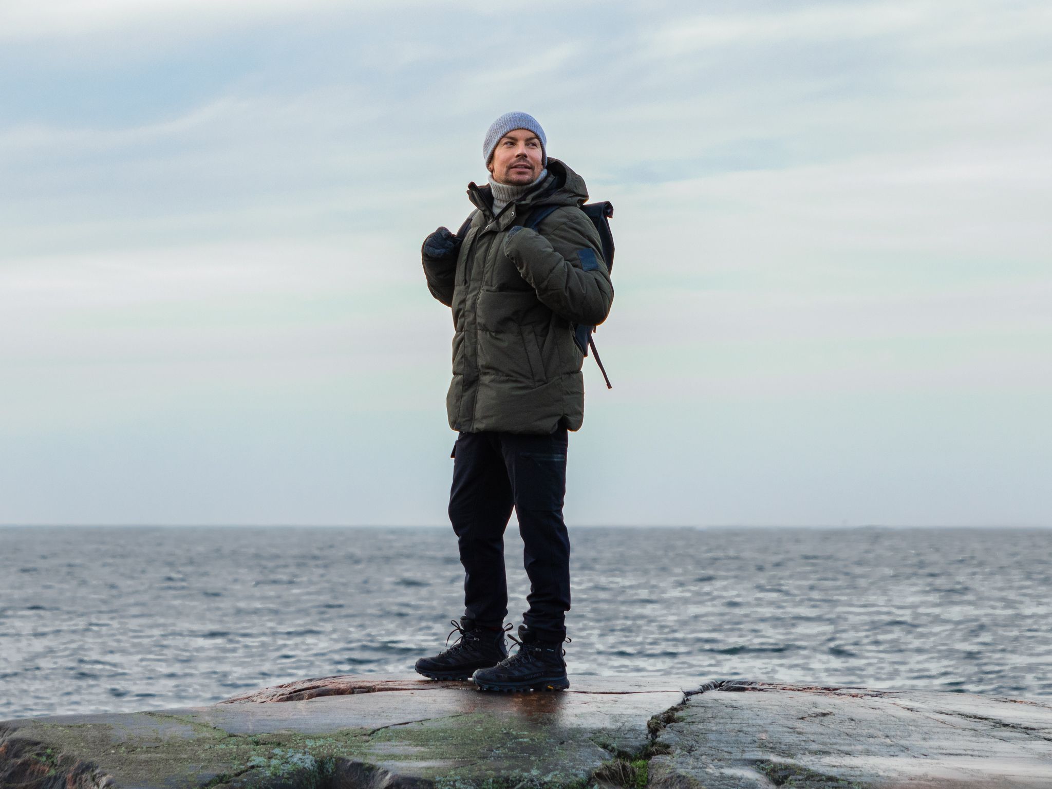 Antti Tuisku seisoo rantakalliolla