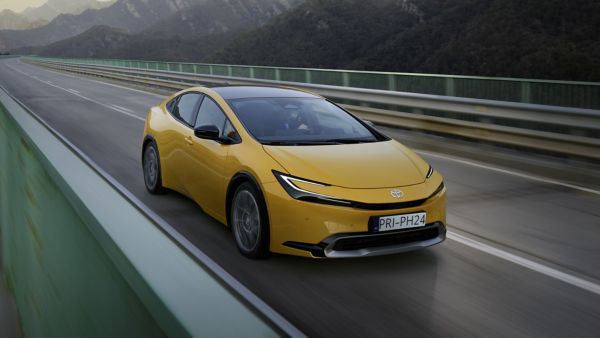 Frau steht an einem Toyota Prius mit Solardach