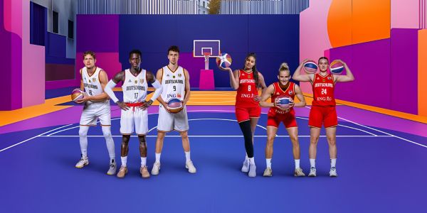 Zwei Basketball Dreierteams stehen auf einem bunten Basketballplatz und posen für die Kamera.