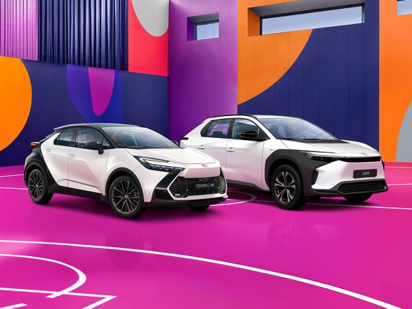 zwei weiß-schwarz lackierte SUVs von Toyota stehen auf einem bunten Basketballfeld.